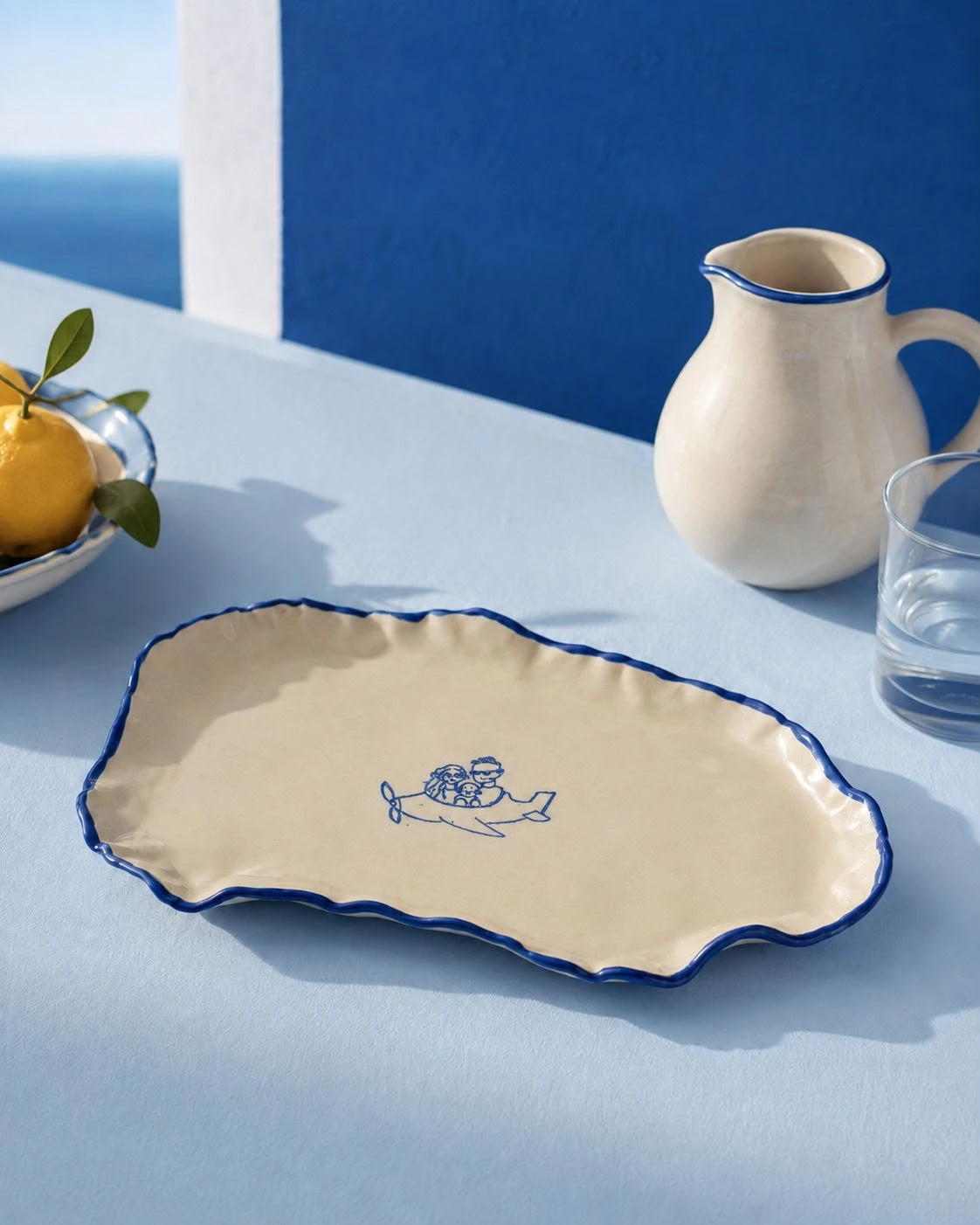 Cream platter with a wavy cobalt-blue rim and a small plane illustration